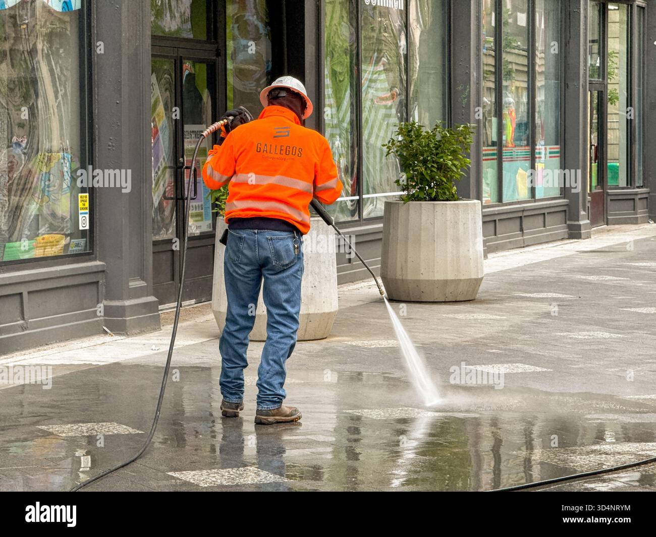 Denver, Colorado, USA - 2 June 2025: Worker pressure washing the pavement on one of the streets in Denver's shopping centre - Smartphone Captured Stock Image