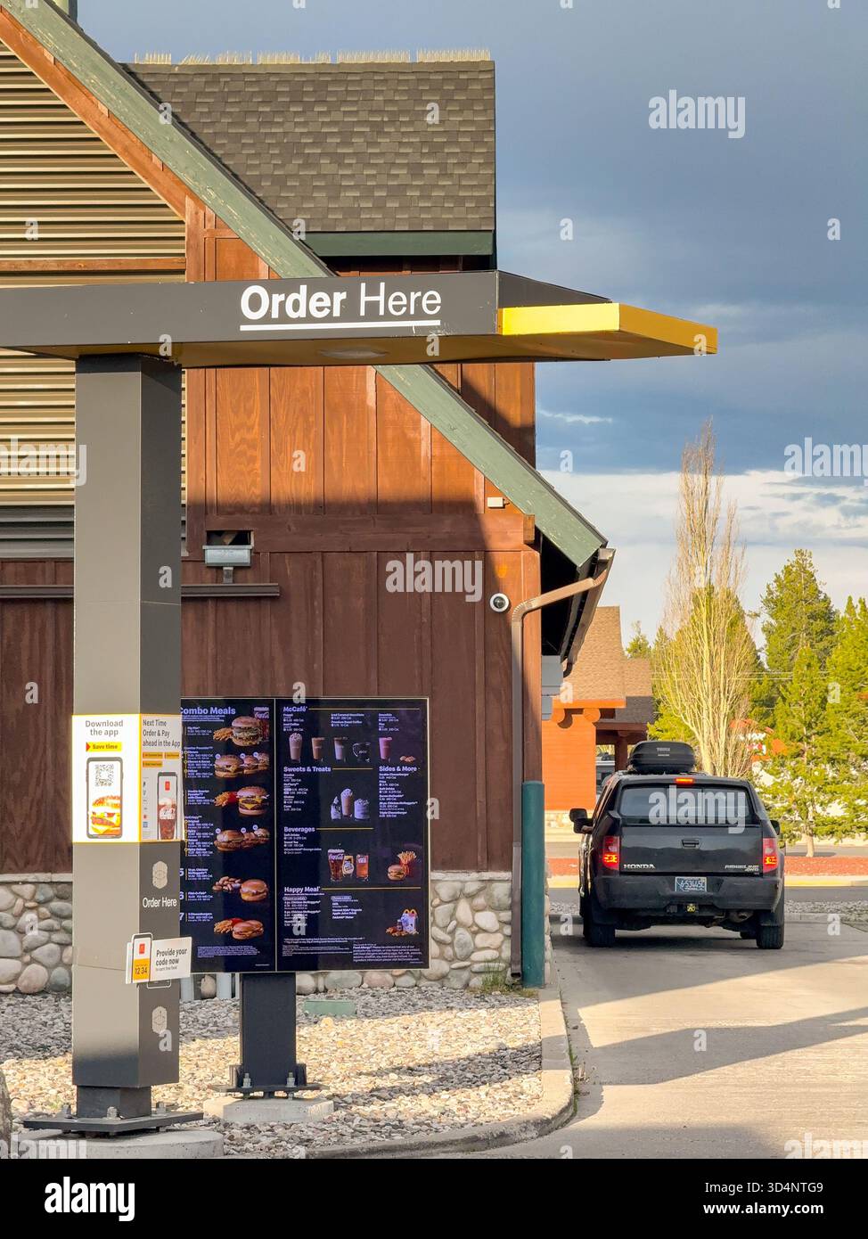 West Yellowstone, Montana, USA - 28 May 2025: Car stopped at the ordering point in a drive thru McDonald's restaurant in West Yellowstone - Smartphone Captured Stock Image