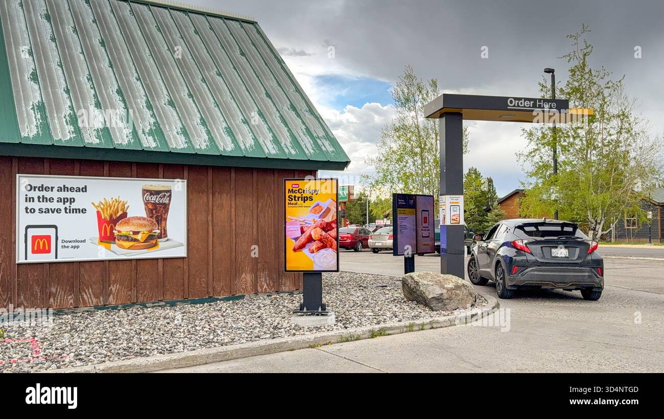 West Yellowstone, Montana, USA - 28 May 2025: Car stopped at the ordering point in a drive thru McDonald's restaurant in West Yellowstone - Smartphone Captured Stock Image