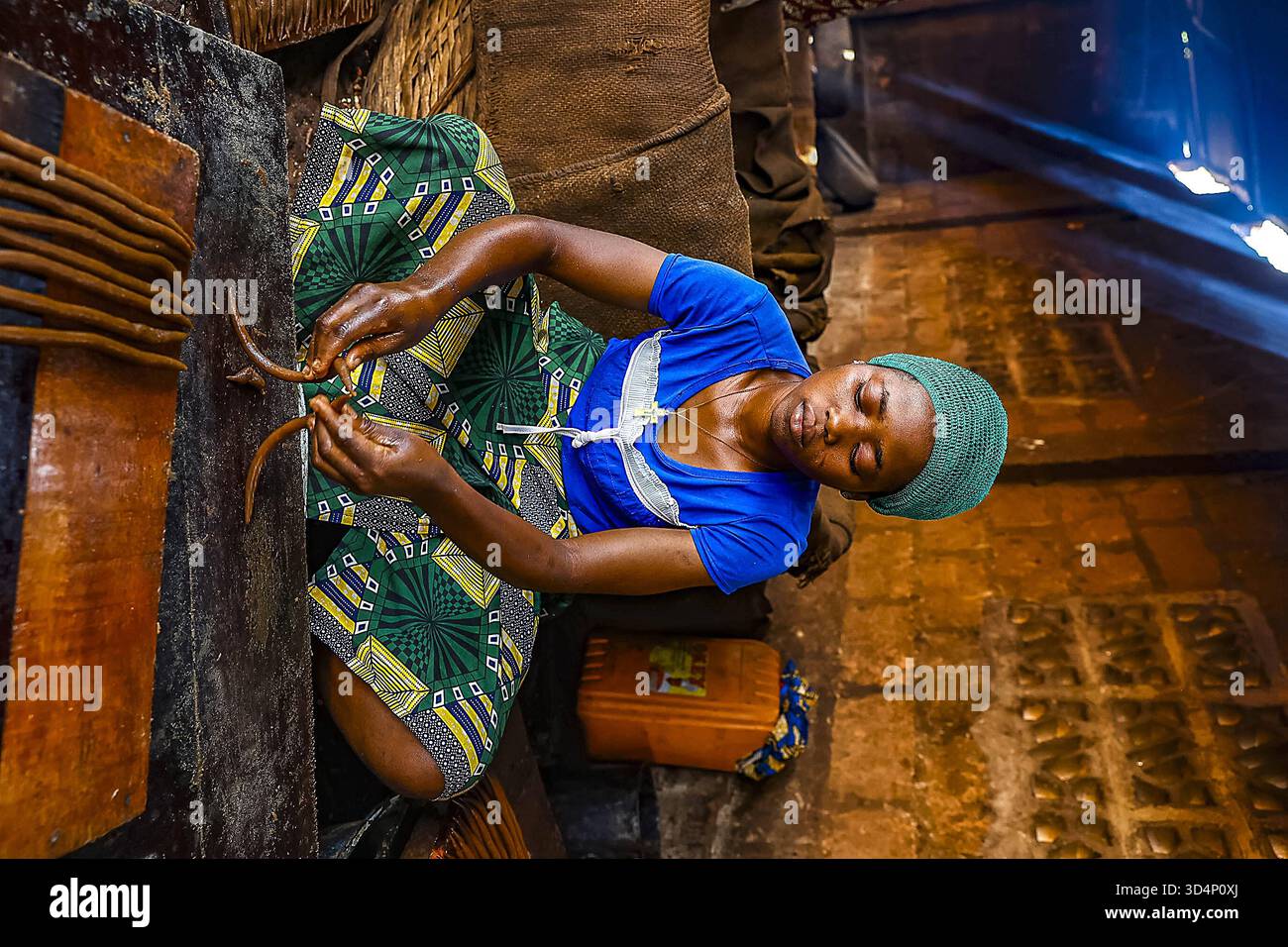 Woman working in a workshop where peanuts are transformed into klui ...