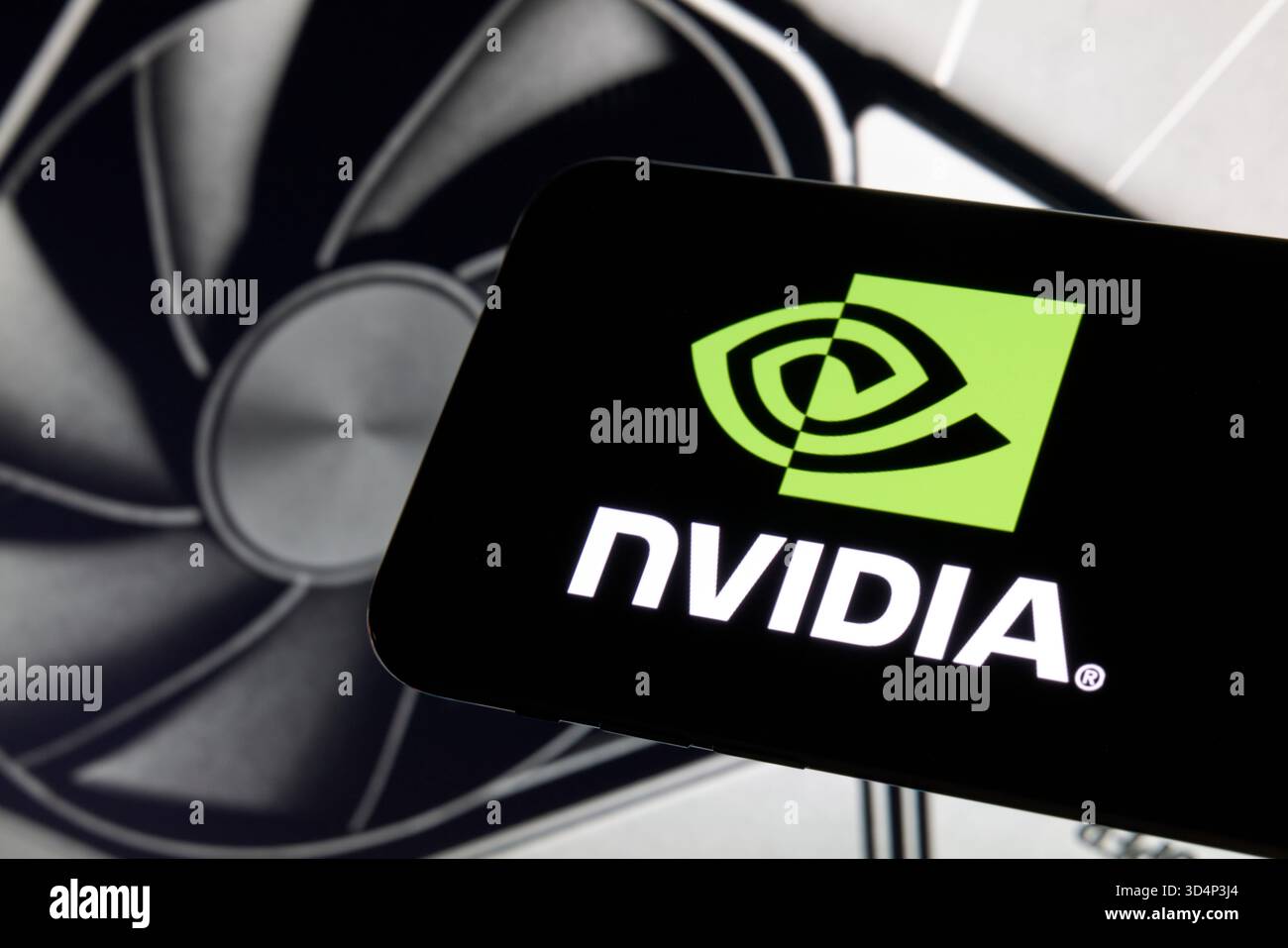 NVIDIA Logo Displayed on Smartphone with GeForce GPU Cooling Fan Stock Photo