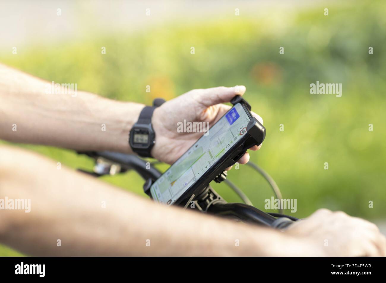 Man planning route using GPS navigation application in mobile phone on his bicycle bike Stock Photo