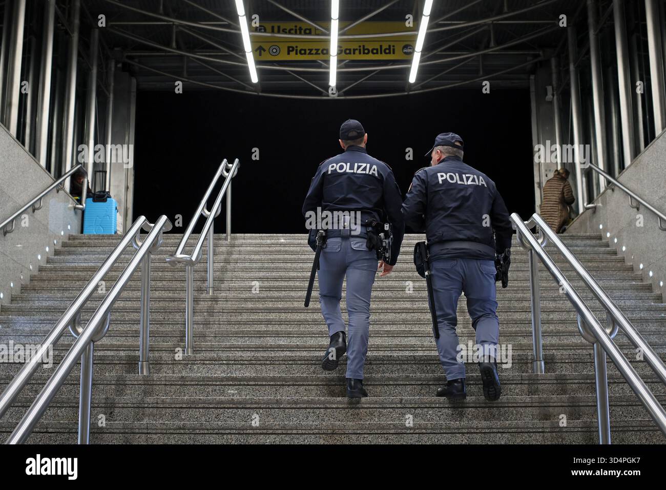 Naples, Italy - November 7, 2025: Two uniformed police officers climb the stairs leading outside the Central Station, patrolling the various areas of Stock Photo