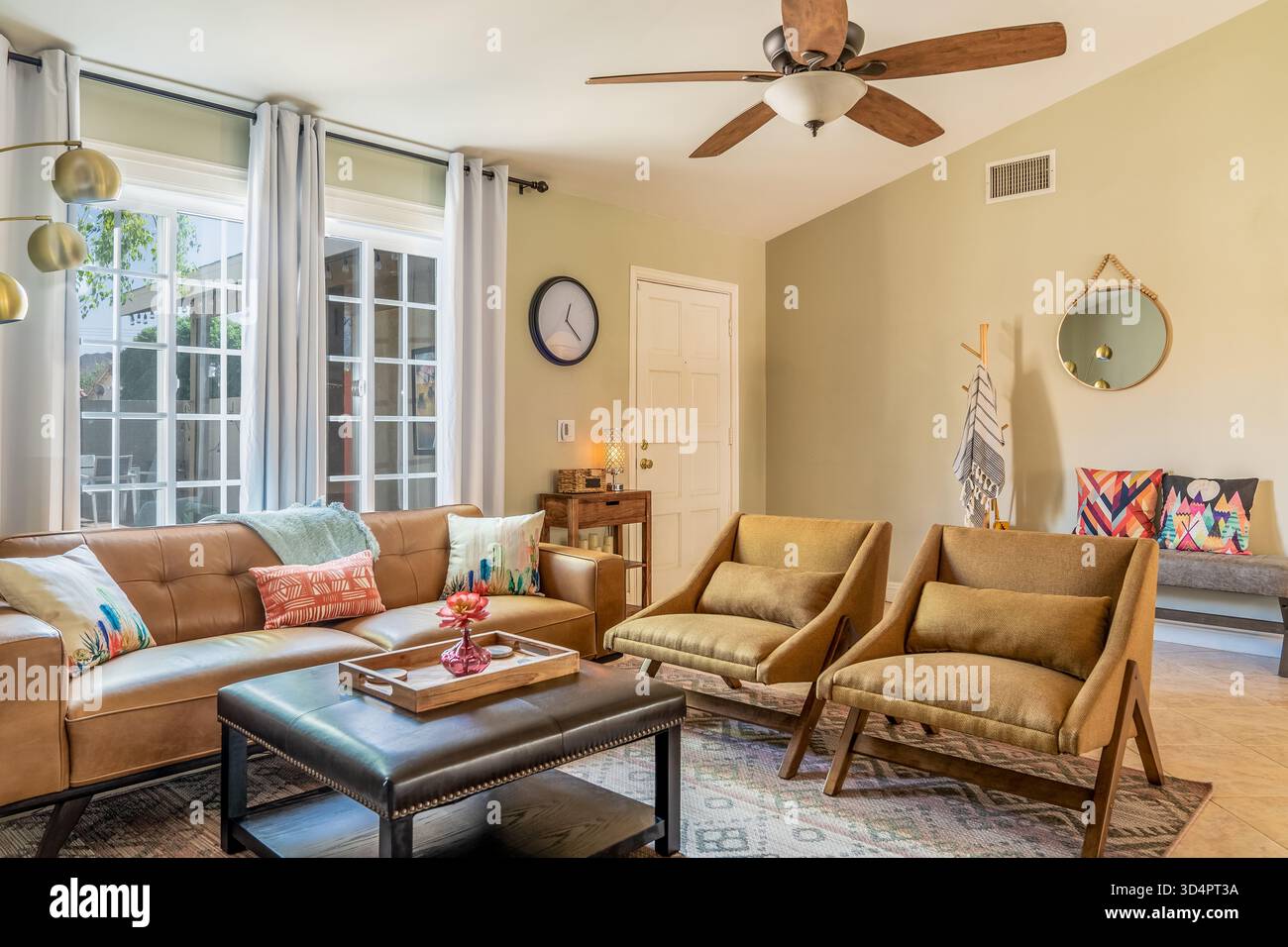 Living room interior with mid-century modern furniture, couch, sofa, chairs, table, and windows Stock Photo