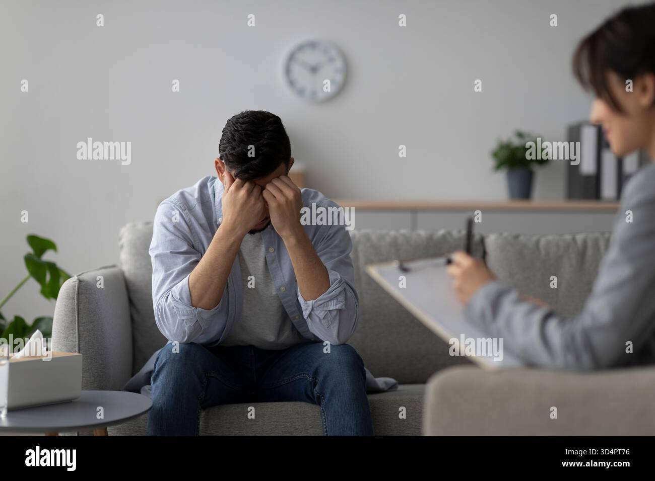 Stressed Man Receives Psychotherapy for Depression in a Calming Office Environment Stock Photo