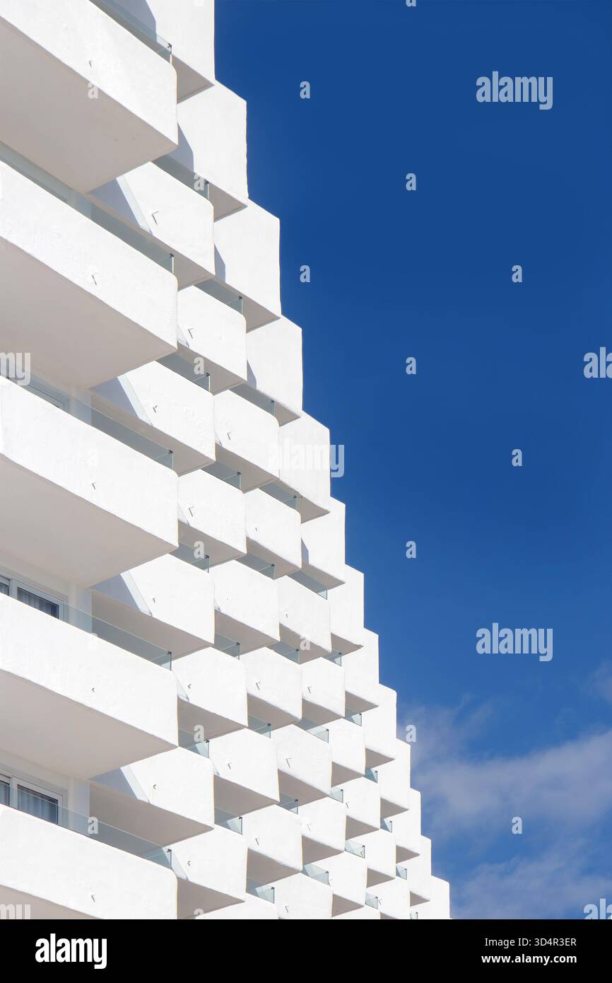 Modern white apartment building with geometric balconies under a ...