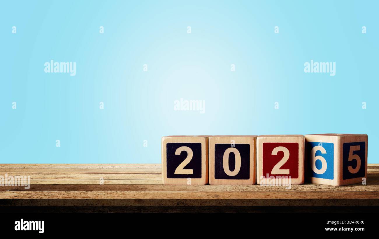 Wooden cubes transform from the number 2025 to 2026 on the table with a ...
