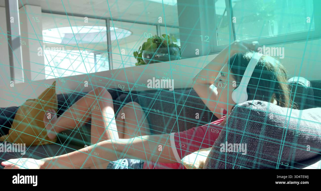 Reclining woman in red shirt listening with white headphones resting on gray sofa amid teal grid Stock Photo