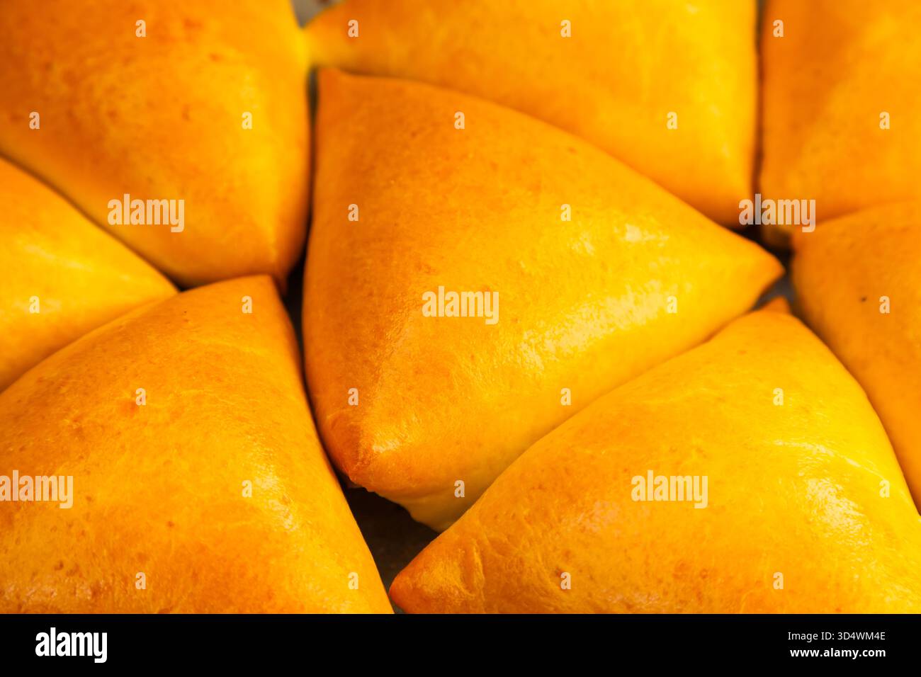 Homemade baked triangular buns lie on white parchment Stock Photo