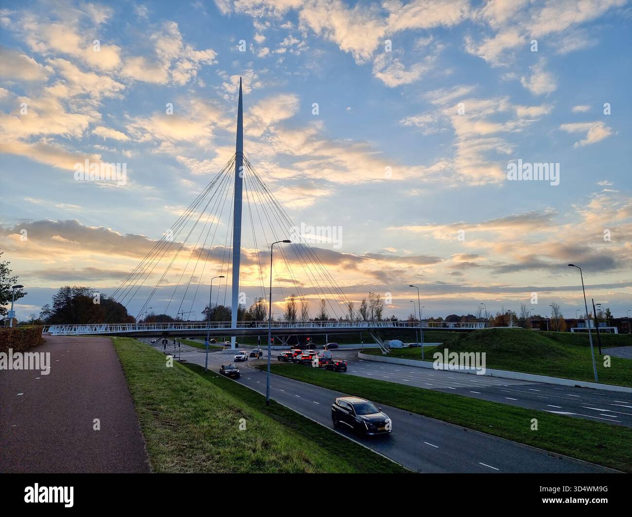 View on the Hovenring, an elevated roundabout for bicycles between Eindhoven & Veldhoven in the Netherlands against a beautiful sunny sky with clouds - Smartphone Captured Stock Image