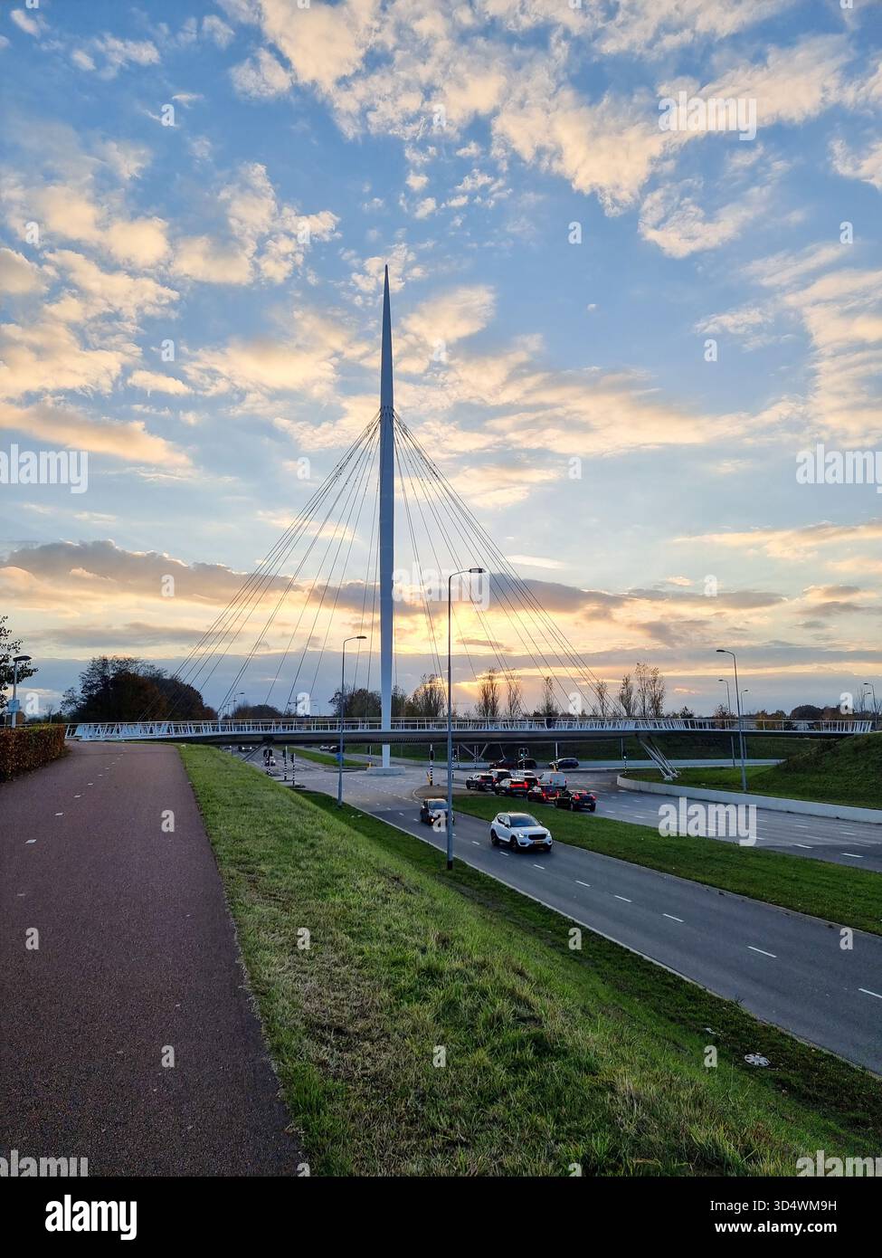 View on the Hovenring, an elevated roundabout for bicycles between Eindhoven & Veldhoven in the Netherlands against a beautiful sunny sky with clouds - Smartphone Captured Stock Image