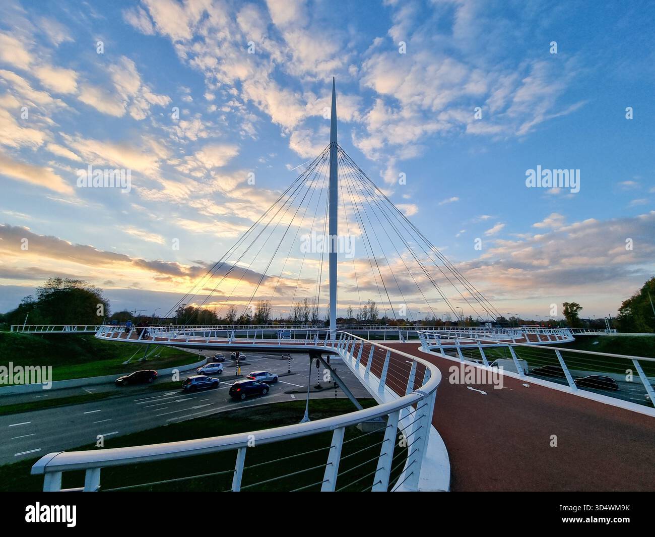 View on the Hovenring, an elevated roundabout for bicycles between Eindhoven & Veldhoven in the Netherlands against a beautiful sunny sky with clouds - Smartphone Captured Stock Image