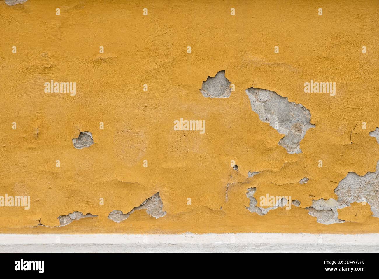 Orange painted concrete wall with paint falling off and worn down Stock Photo
