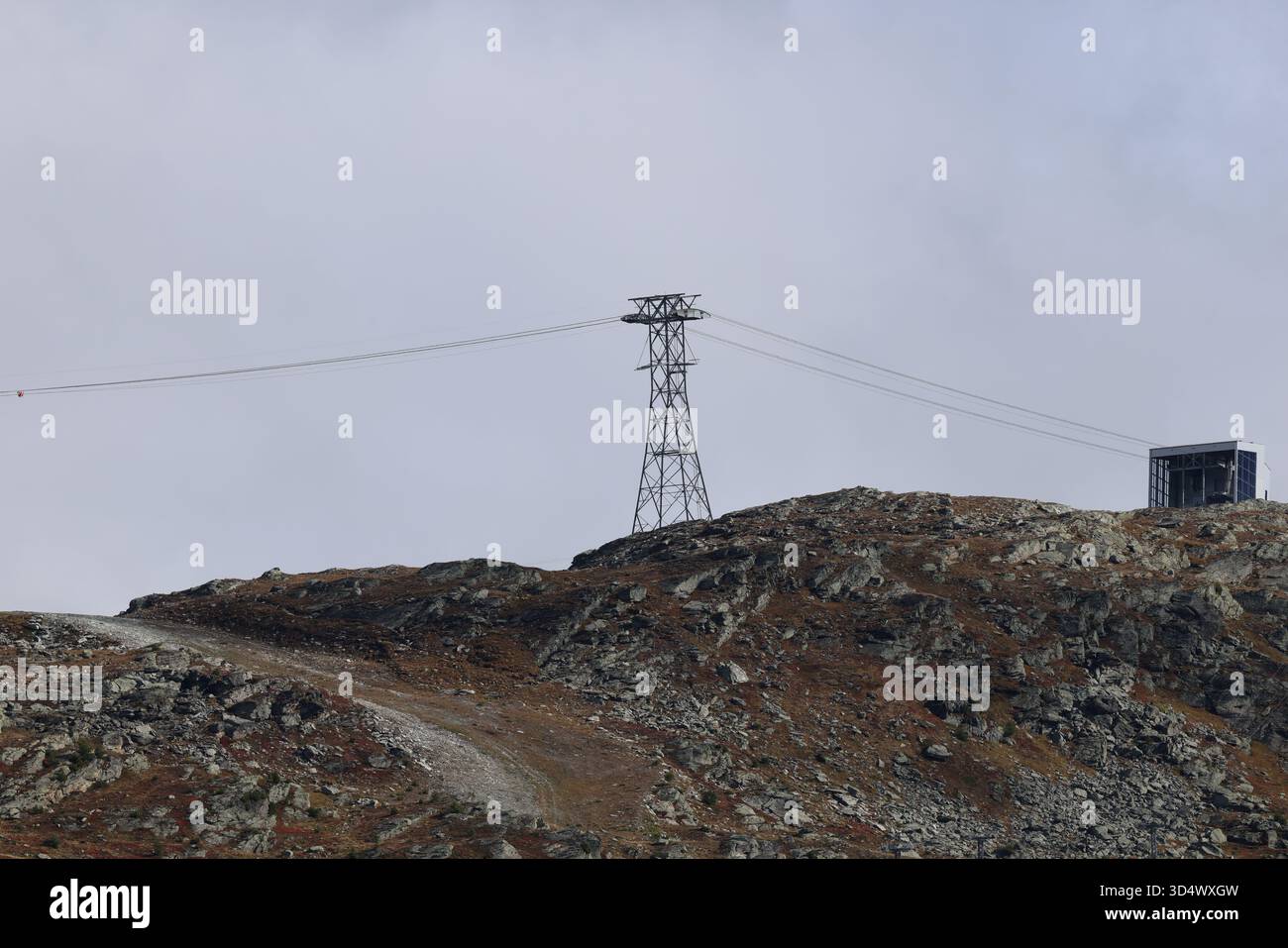 Cable car tower on rocky mountain ridge under cloudy sky Stock Photo ...