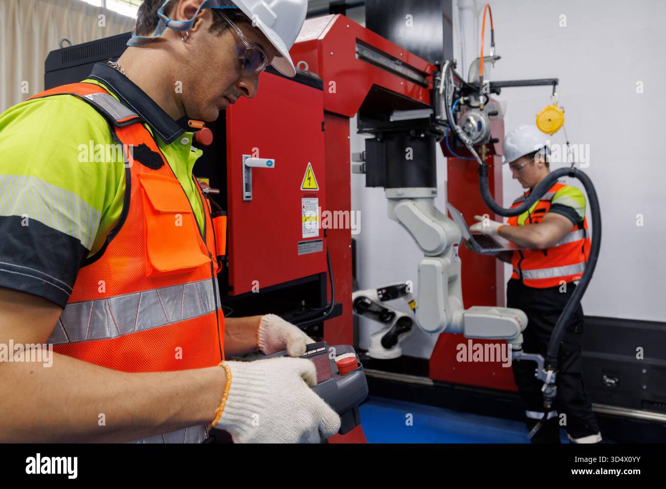 Robotic Engineer Operator Engineer and technician working with industrial robot arm in modern ...