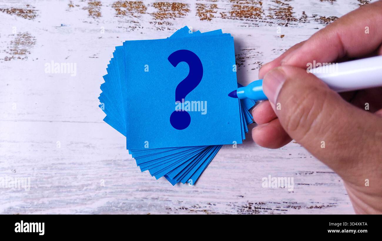 Hand Writing Question Mark: Stack of Blue Sticky Notes with Marker Pen Stock Photo