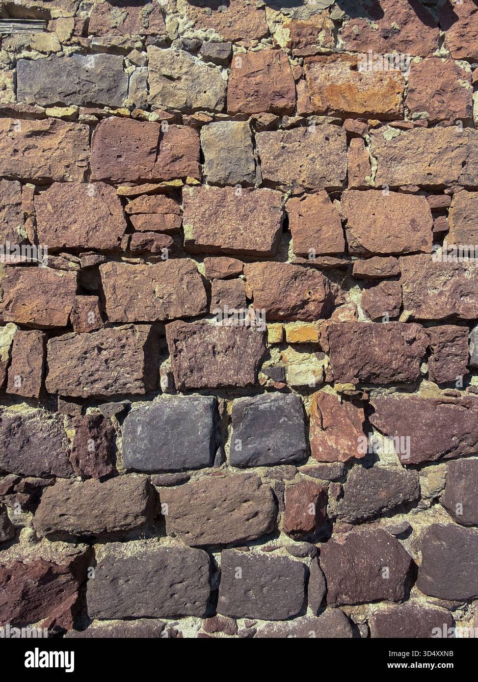 Rustic Stone Wall Texture with Mixed Volcanic Rocks Stock Photo