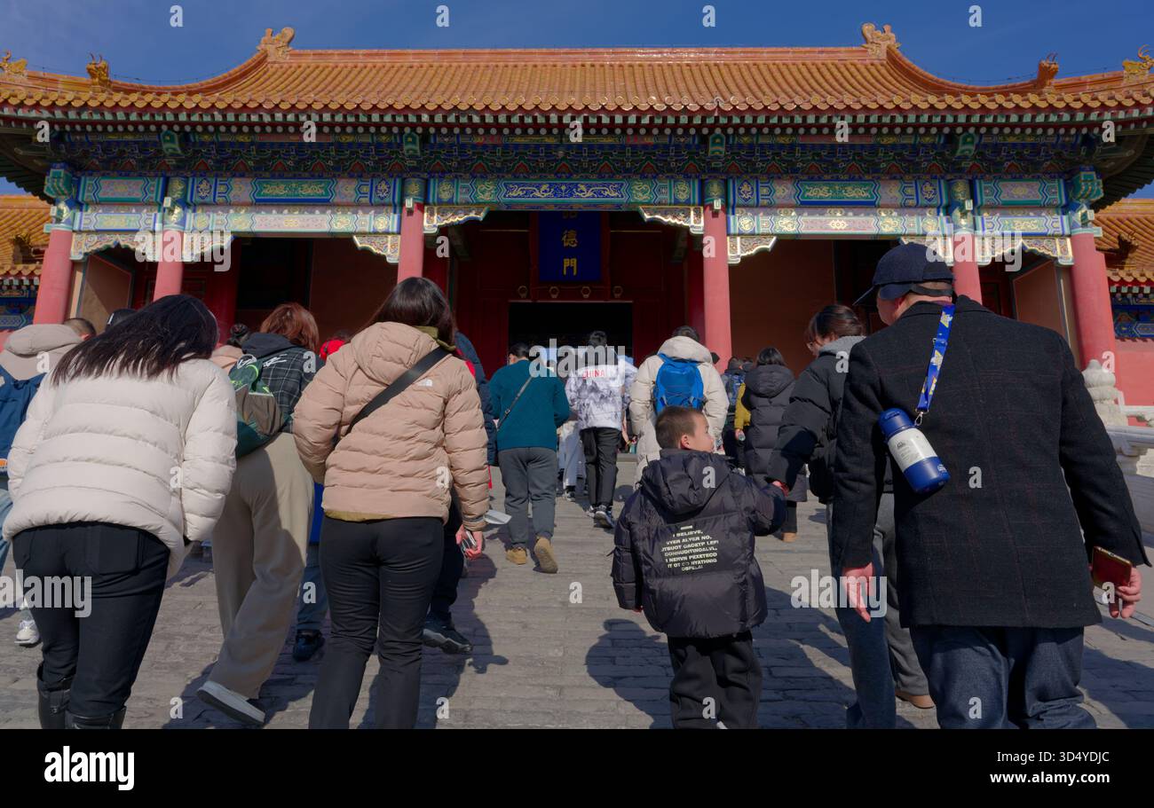 Inside the Forbidden City, visitors climb stone steps toward an ornate gate Stock Photo