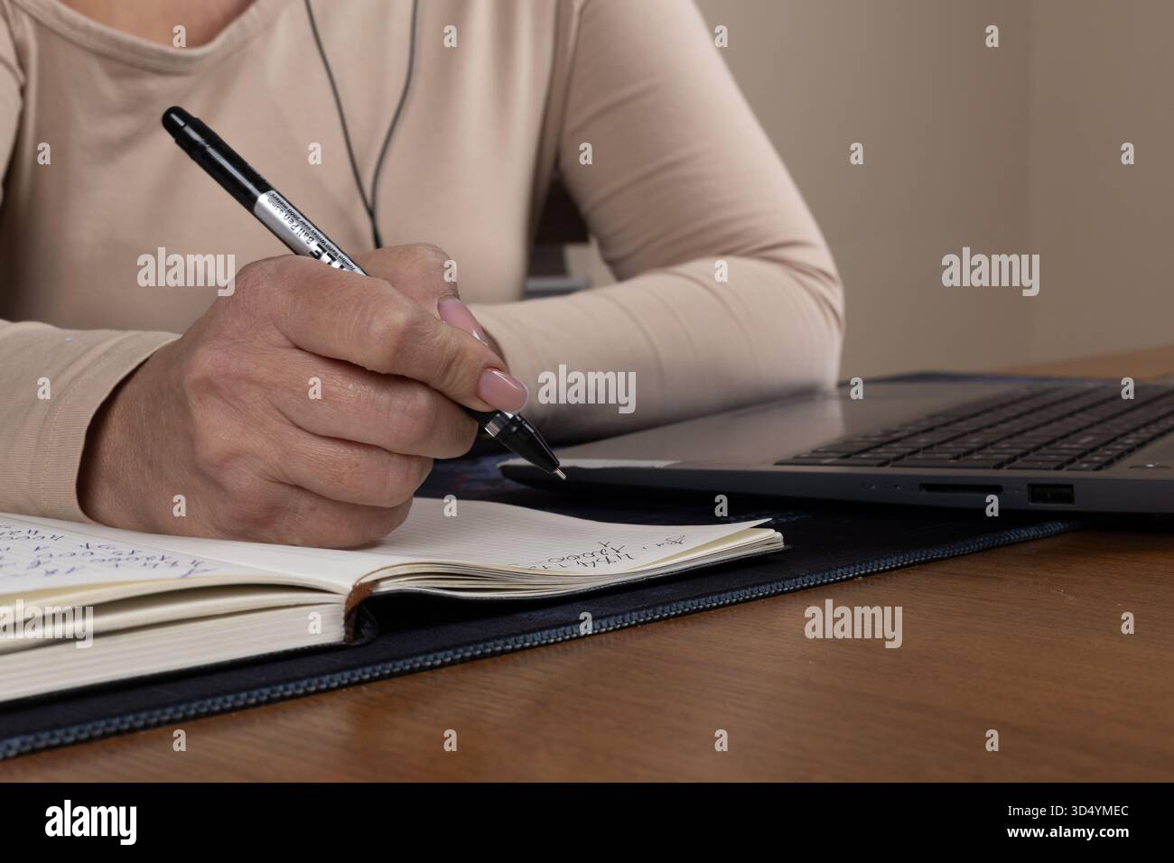 The journalist is diligently taking notes for an upcoming news report Stock Photo