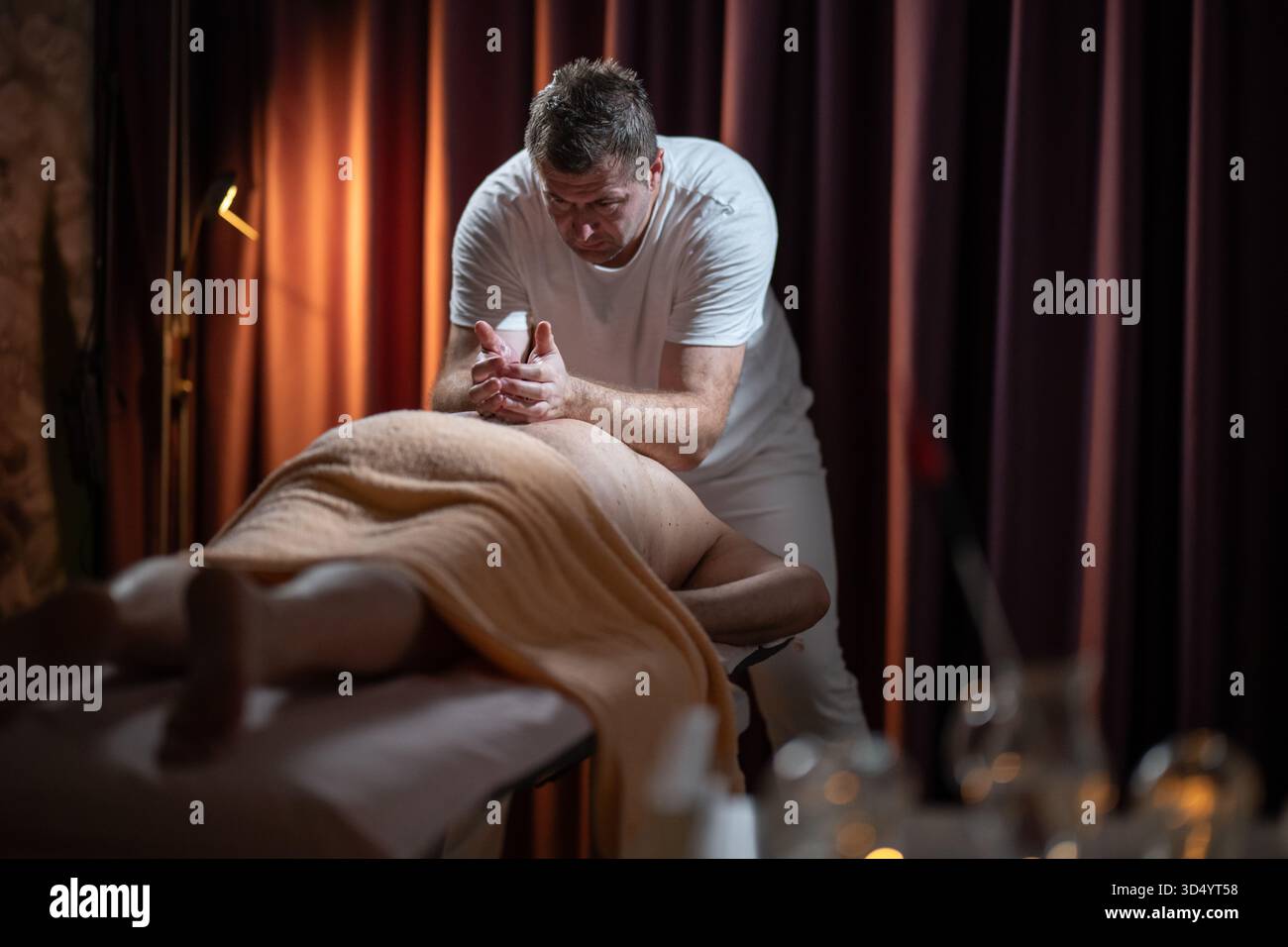 professional-male-massage-therapist-performing-deep-tissue-back-massage