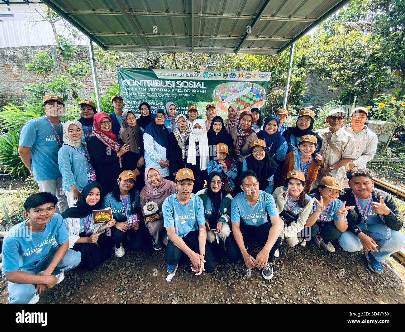 A group of students, lecturers, and community members participating in the 'Kontribusi Sosial' (Social Contribution) - Smartphone Captured Stock Image