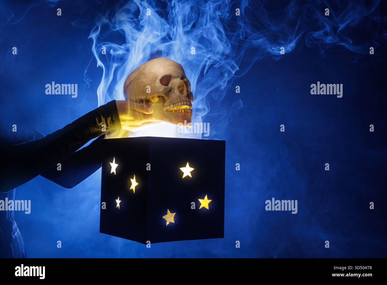 Skull lifted from a glowing star box with swirling blue smoke, perfect for Halloween ads, horror posters, teasers and spooky concept art. Stock Photo