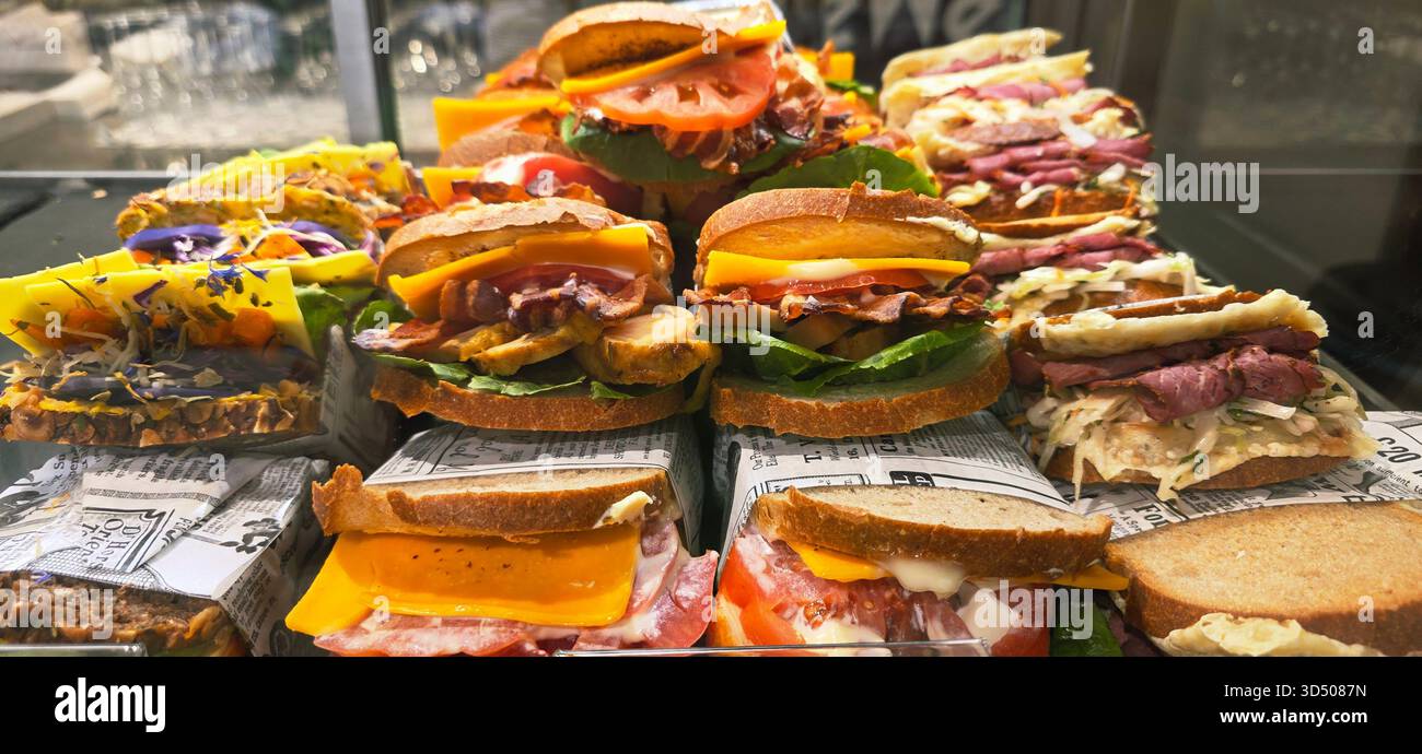 Berlin, Germany - September 19, 2025: Gourmet sandwiches are beautifully arranged in a glass case showcasing fresh ingredients. - Smartphone Captured Stock Image