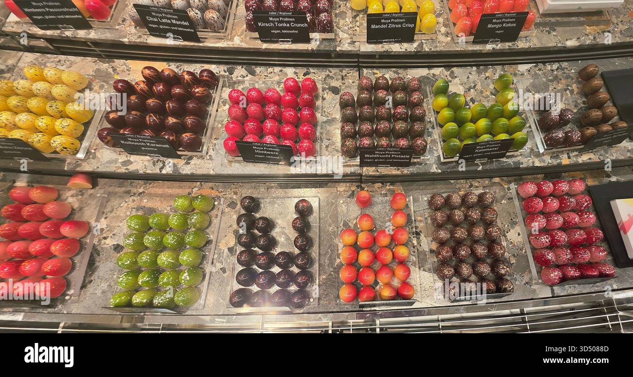 Berlin, Germany - September 19, 2025: Colorful gourmet chocolates are beautifully arranged in a shop display. - Smartphone Captured Stock Image