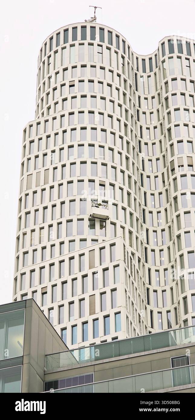 Berlin, Germany - September 22, 2025: High-rise building features unique design with curved facade and glass elements. - Smartphone Captured Stock Image