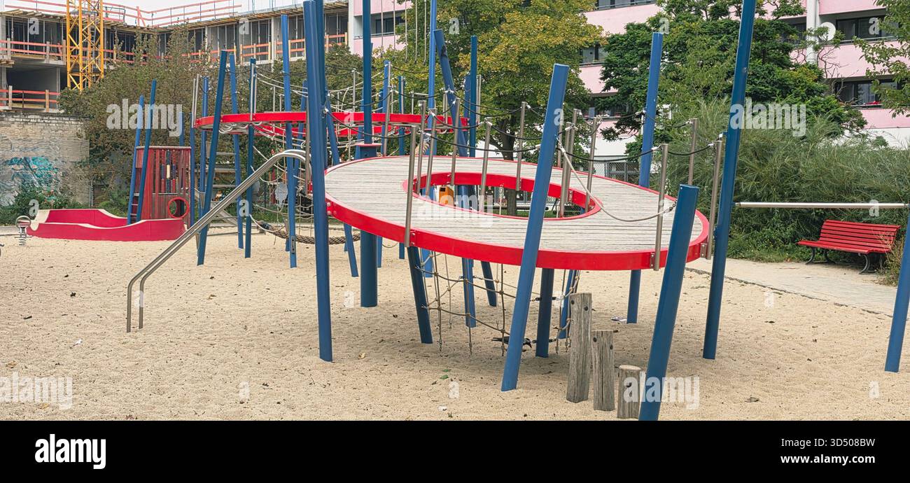 Berlin, Germany - September 25, 2025: Colorful playground features climbing structures and slides in sandy area. - Smartphone Captured Stock Image