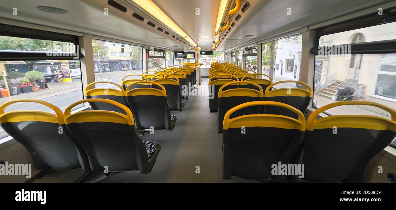 Berlin, Germany - September 25, 2025: Interior view of an empty city bus featuring yellow seats and bright windows. - Smartphone Captured Stock Image