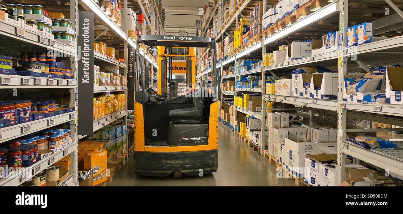 Berlin, Germany - September 27, 2025: Forklift is navigating through grocery warehouse aisle with shelves stocked with products. - Smartphone Captured Stock Image