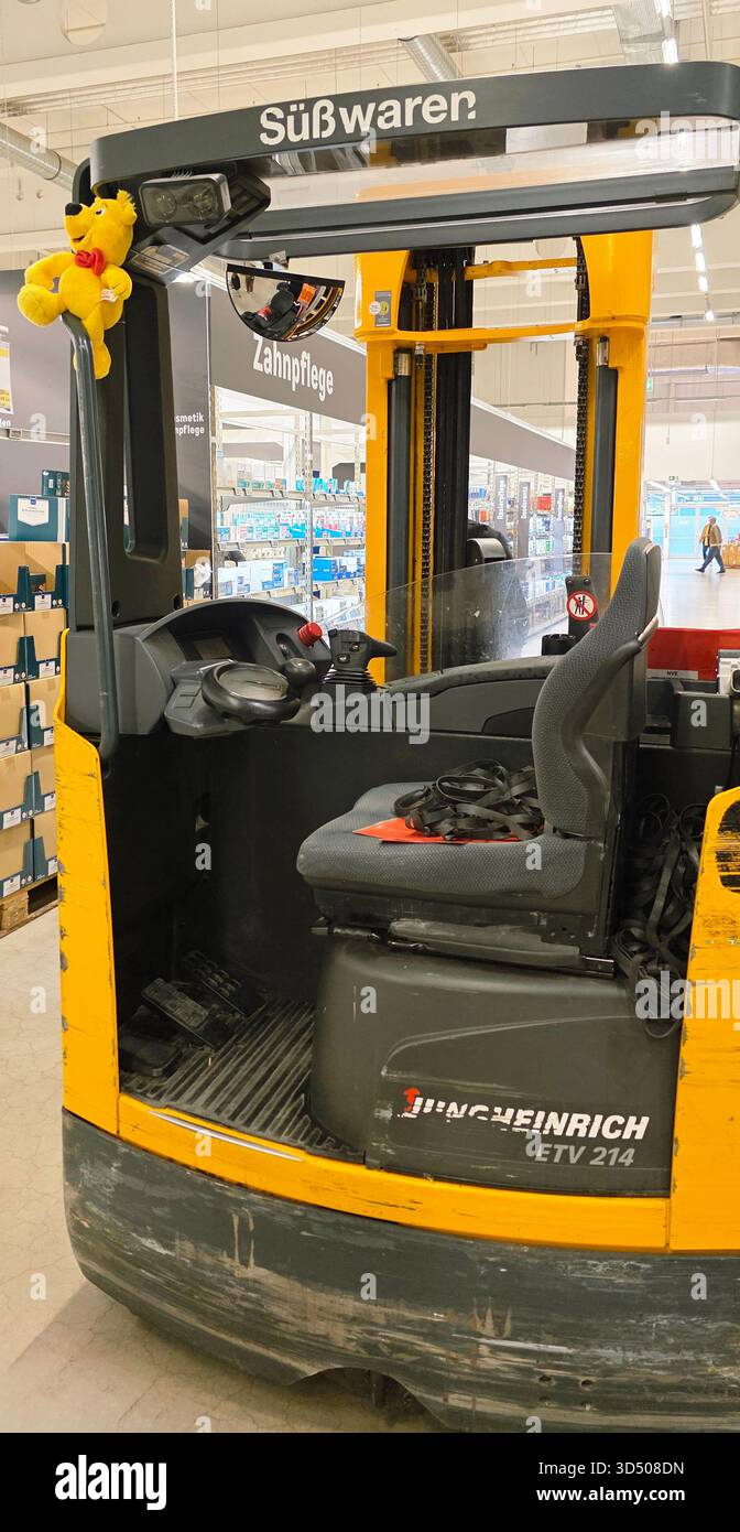 Berlin, Germany - September 27, 2025: Yellow Jungheinrich forklift parked in warehouse with plush toy hanging inside. - Smartphone Captured Stock Image