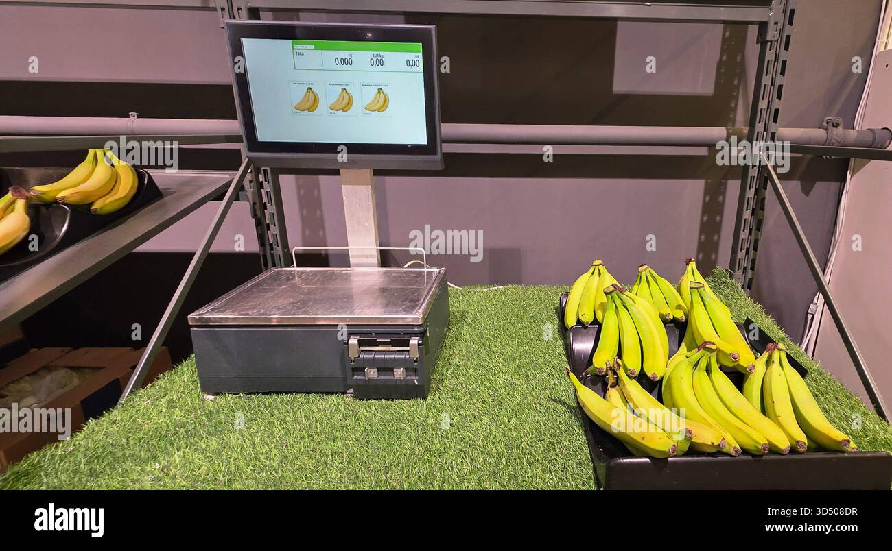 Berlin, Germany - September 27, 2025: Digital scale shows bananas in grocery store with artificial grass surface. - Smartphone Captured Stock Image