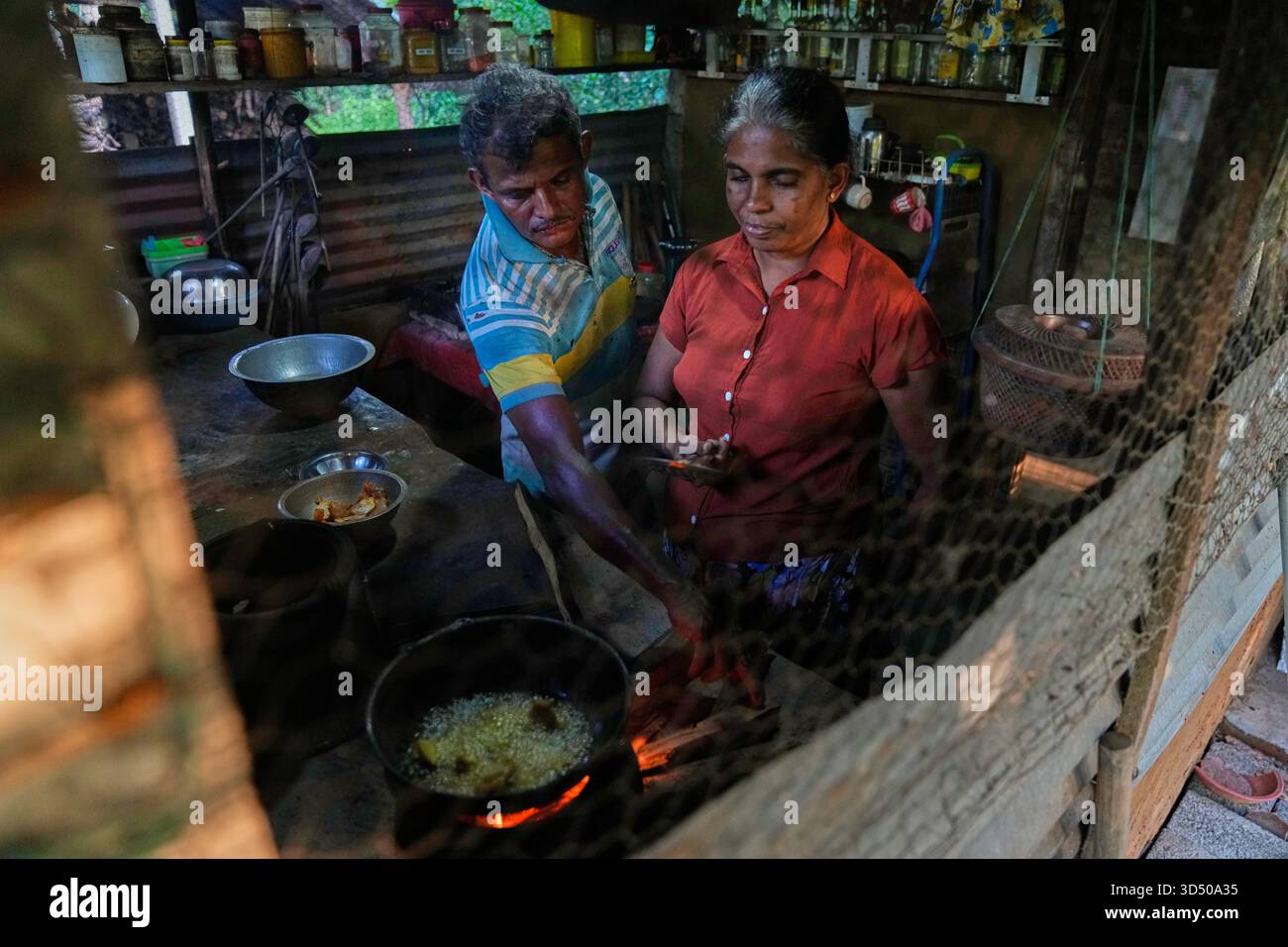 Ranjith Kumara helps his wife Kusumalatha as she cooks a giant ...