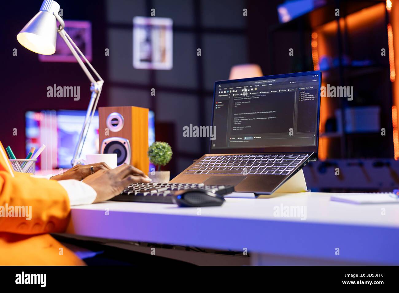 Engineer at desk typing code on notebook device, developing software programs, entering commands. Person at home fixing errors in application, implementing new features, close up Stock Photo