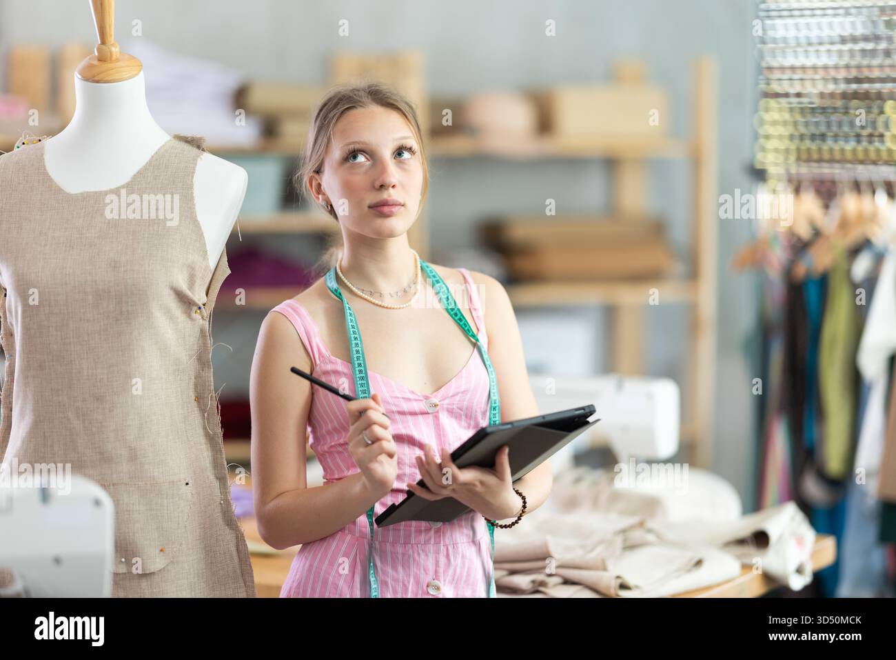 Woman dressmaker makes pattern using tablet Stock Photo