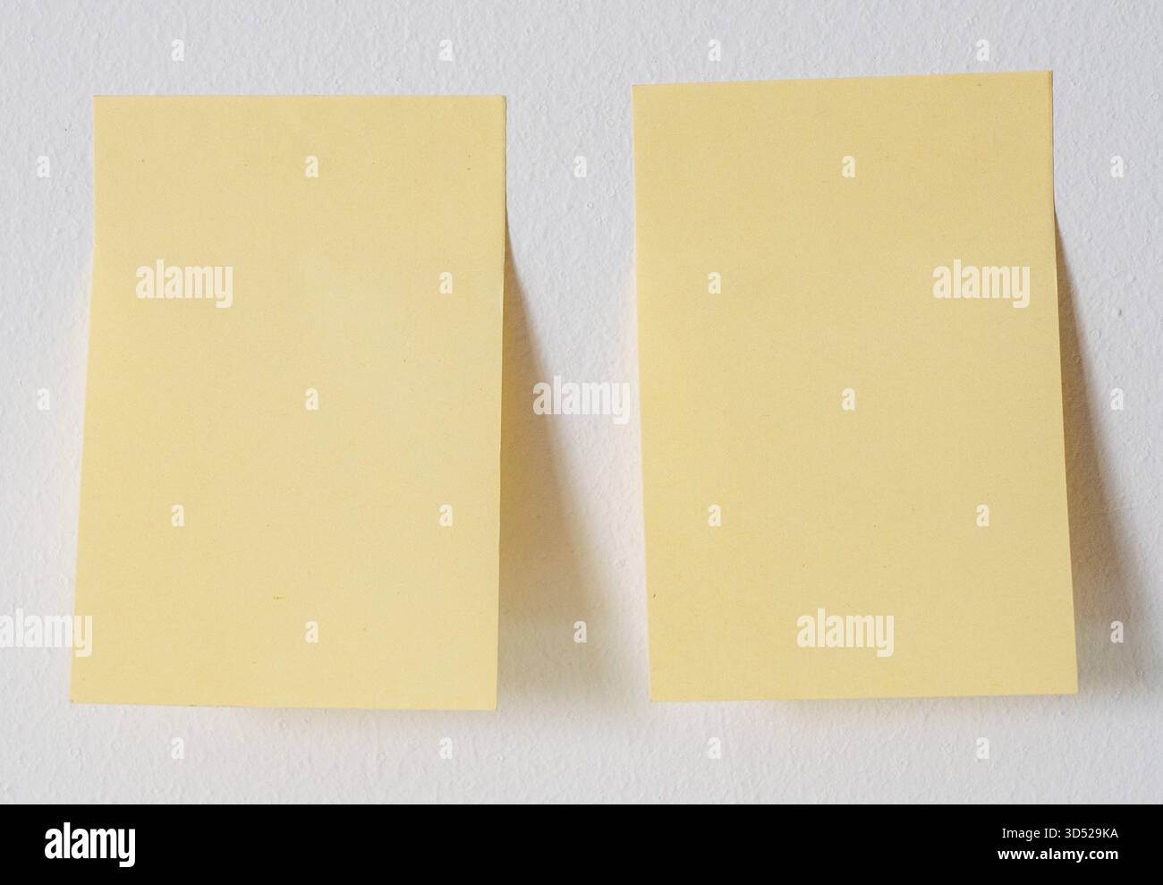 Two sticky notes on white wall Stock Photo