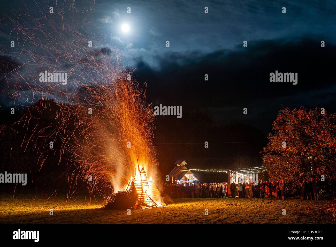 Crowds watching the bonfire beneath a rising full moon, at the 2017 Bonfire Night celebrations in the Welsh border town of Presteigne Stock Photo