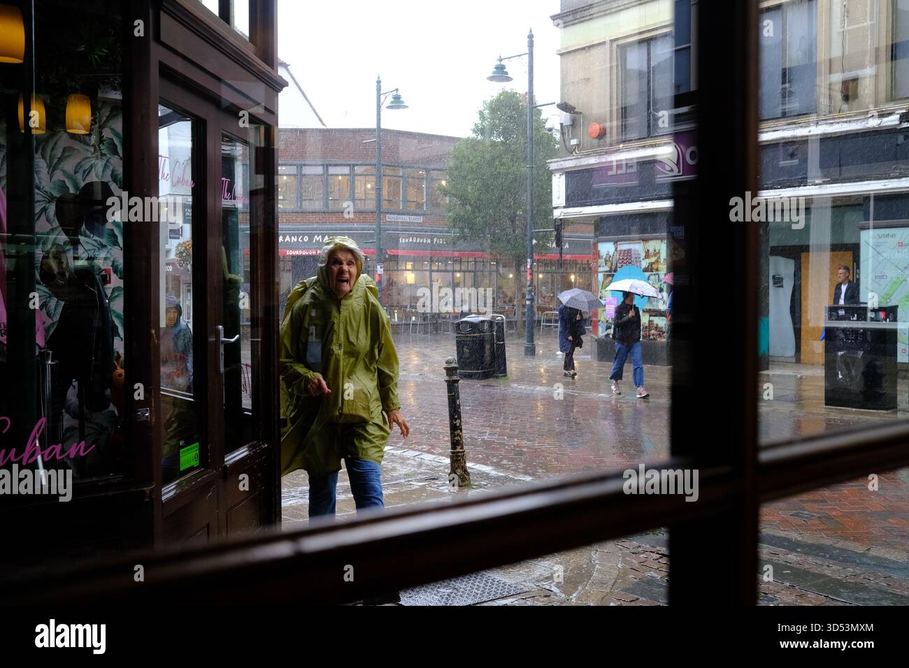 Pedestrians struggle  using hoods and umbrellas against the torrential rains in Canterbury Kent 13/11/2025 Stock Photo