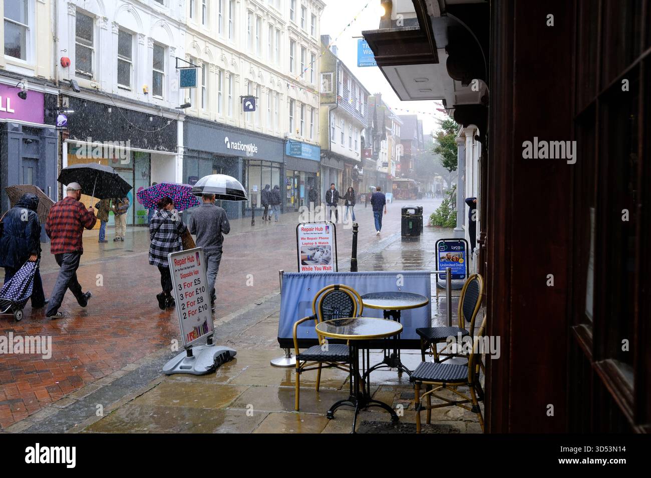 Pedestrians struggle against the torrential rains in Canterbury 13/11/2025 Stock Photo