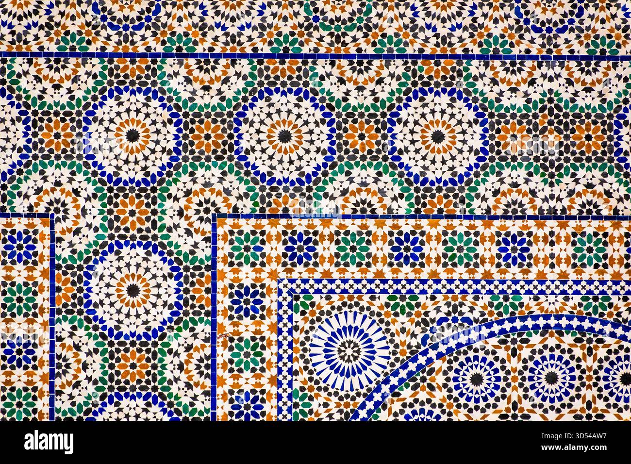 Casablanca, Morocco – Close-up of a colorful traditional Moroccan zellige mosaic tile pattern featuring geometric shapes in blue, green, brown, and wh Stock Photo