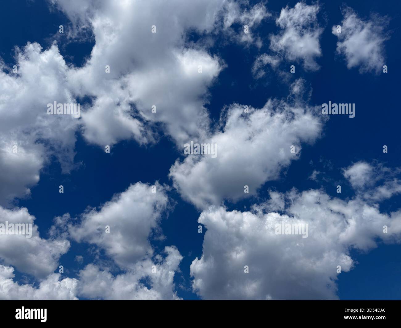 Puffy clouds in blue sky Stock Photo