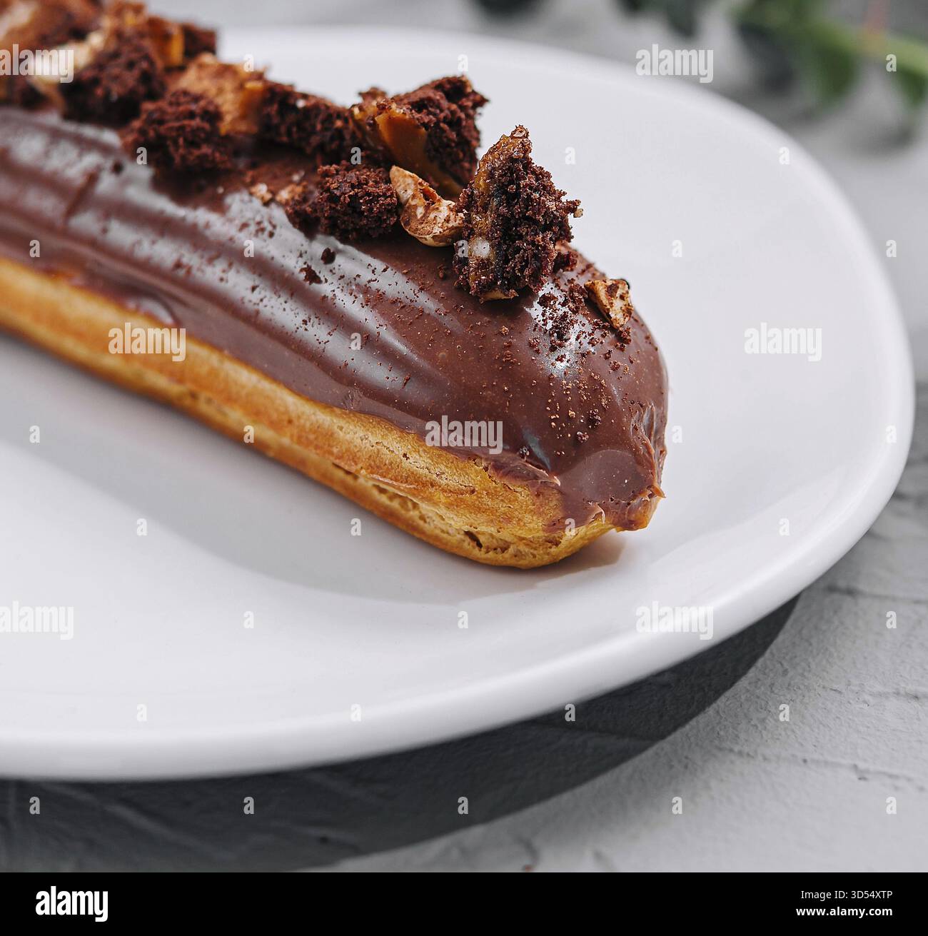 Food, Eclair with Chocolate Cream and Hazelnuts closeup Stock Photo