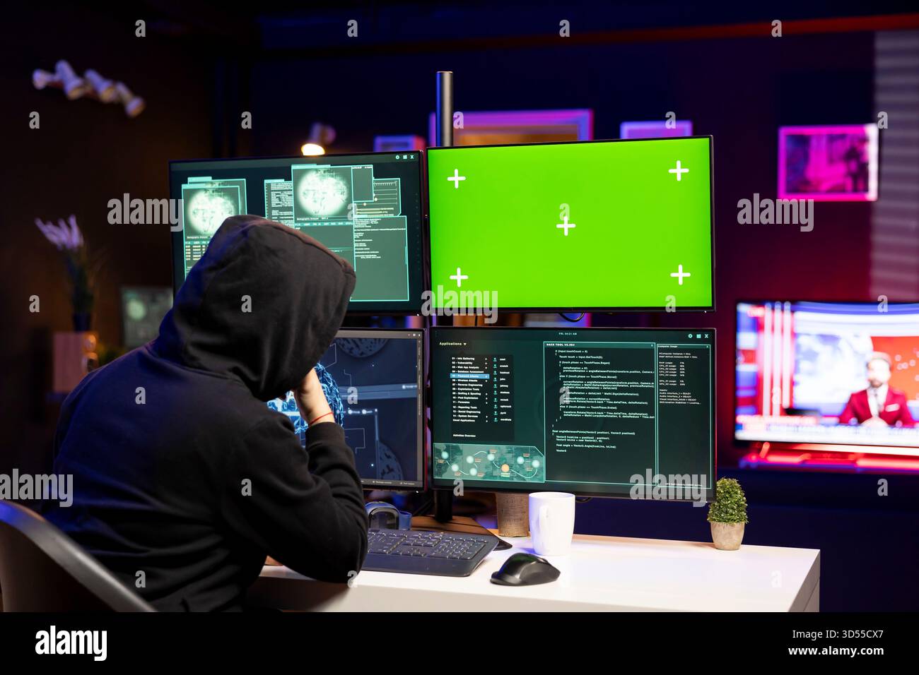 Cybercriminal coding on green screen PC, creating stealth malware that evades security. Hacker using chroma key computer to make script hiding malicious code from detection systems Stock Photo