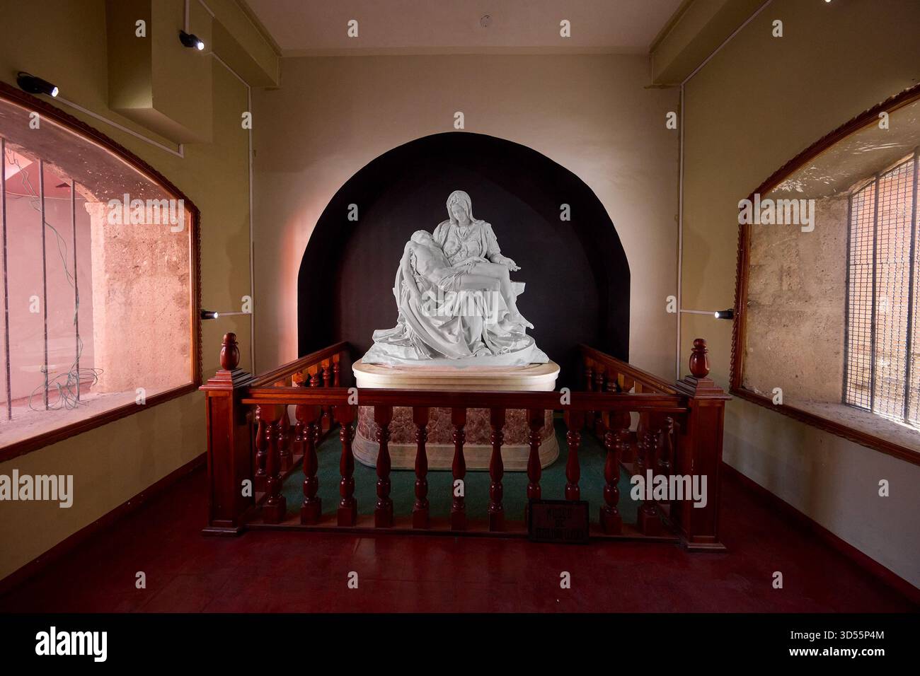 A quiet moment of devotion before Lampa’s treasured replica of Michelangelo’s Pietà, where artistry, faith, and Andean silence come together in a sing Stock Photo