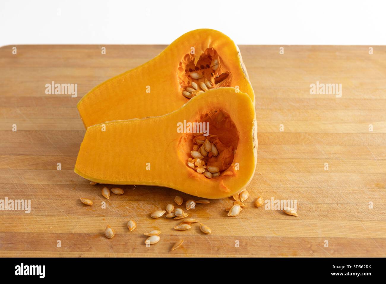 Butternut Squash cut in half on a wooden cutting board Stock Photo