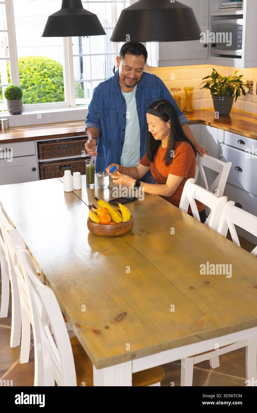 Mature couple enjoying breakfast together in bright kitchen, sharing joyful moment Stock Photo