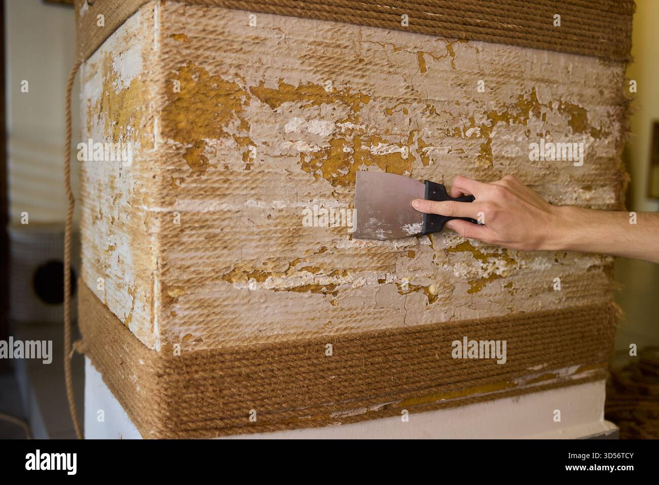 Applying Putty on a Wall Surface Using a Scraper Tool for a Smooth Finish and Texture Stock Photo