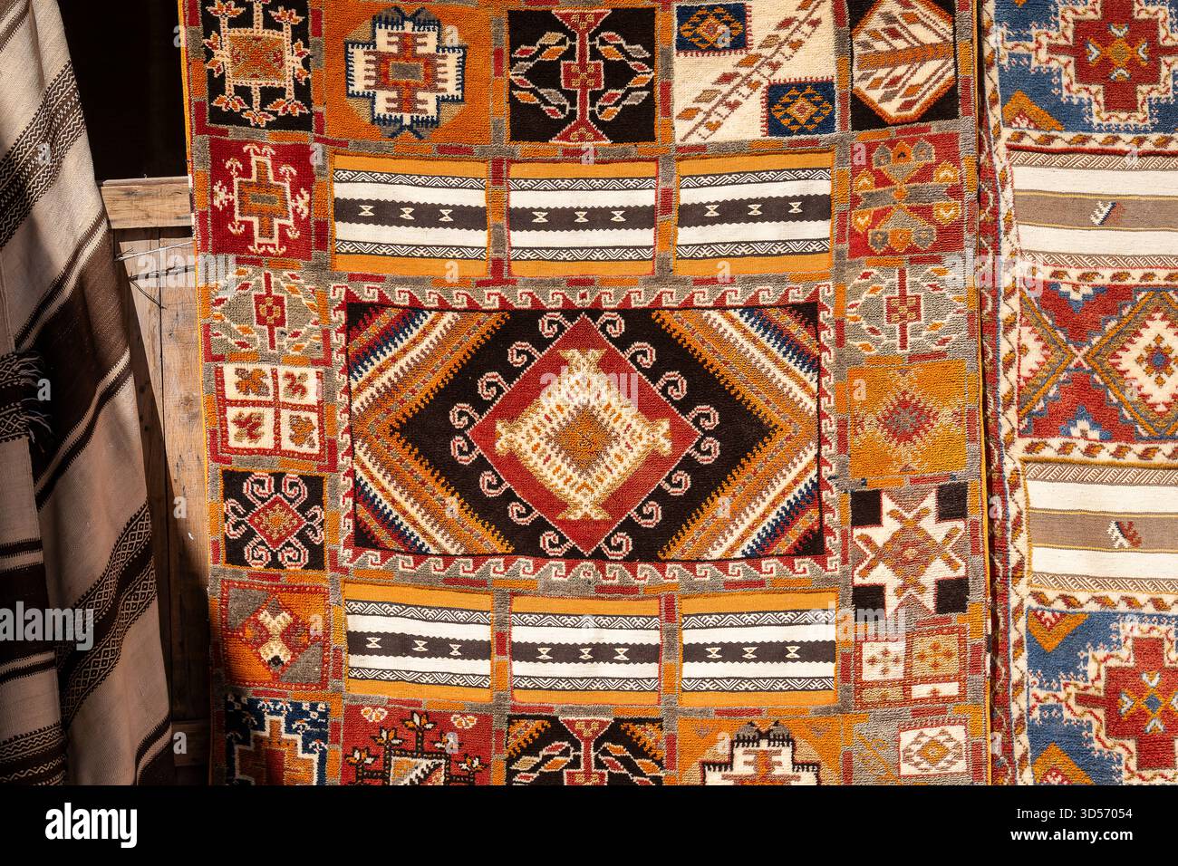 Moroccan carpets with oriental ornaments for sale on a street shop in Kasbah Ait Ben Haddou near Ouarzazate in the Atlas Mountains of Morocco. Stock Photo